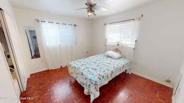 bedroom featuring dark parquet floors, a closet, and ceiling fan