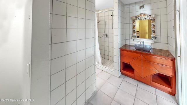 bathroom featuring tile patterned floors, vanity, tile walls, and walk in shower