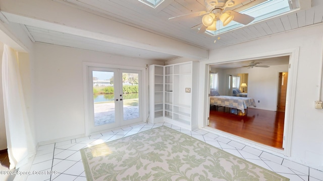 interior space featuring ceiling fan, french doors, light tile patterned floors, and wooden ceiling