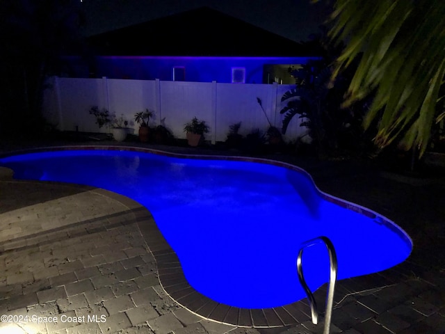 pool at twilight featuring a patio