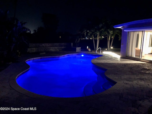 pool at twilight with a patio