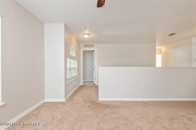 carpeted empty room featuring a textured ceiling