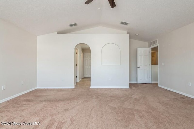 carpeted empty room with lofted ceiling, a textured ceiling, and ceiling fan