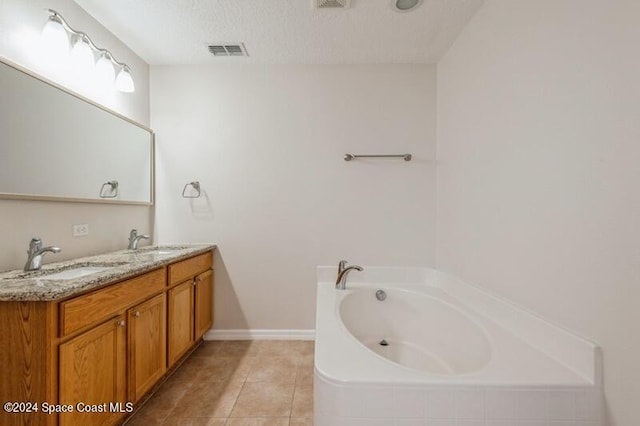 bathroom with vanity, tiled bath, a textured ceiling, and tile patterned flooring