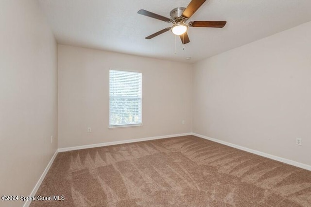 carpeted spare room featuring ceiling fan