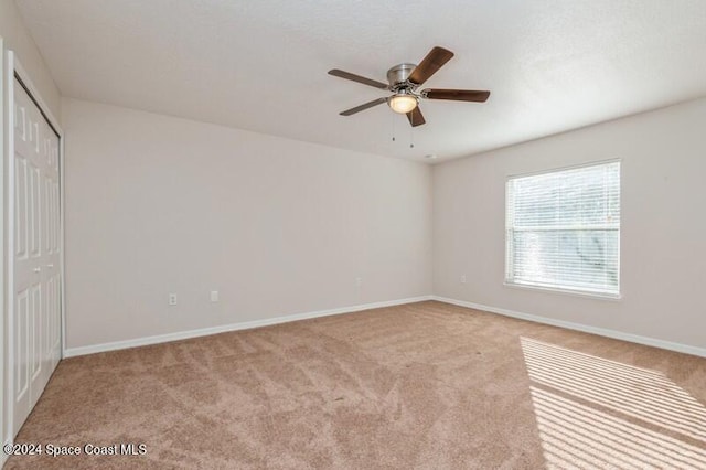 unfurnished room featuring ceiling fan and light colored carpet