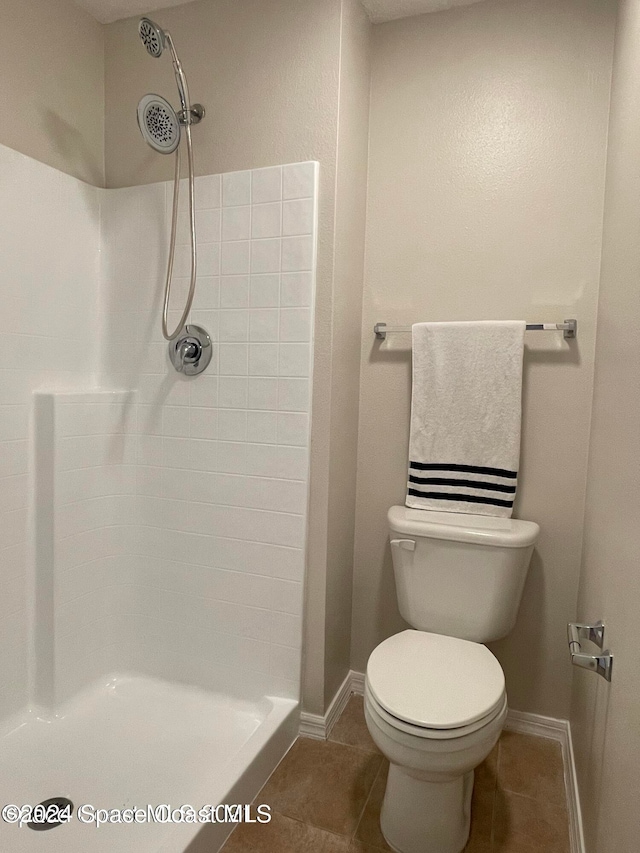 bathroom with toilet, tile patterned floors, and walk in shower