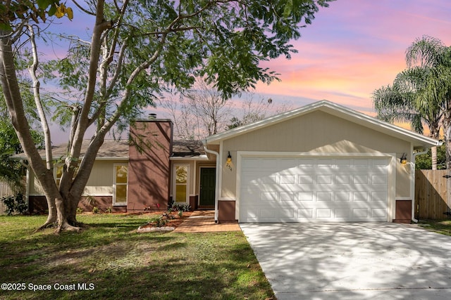 ranch-style home with a yard and a garage