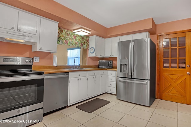 kitchen featuring appliances with stainless steel finishes, white cabinetry, sink, and light tile patterned floors