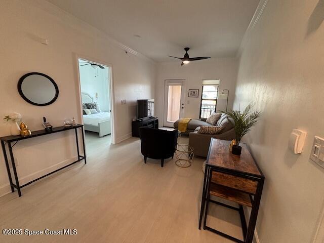 living room with ceiling fan, light hardwood / wood-style floors, and ornamental molding