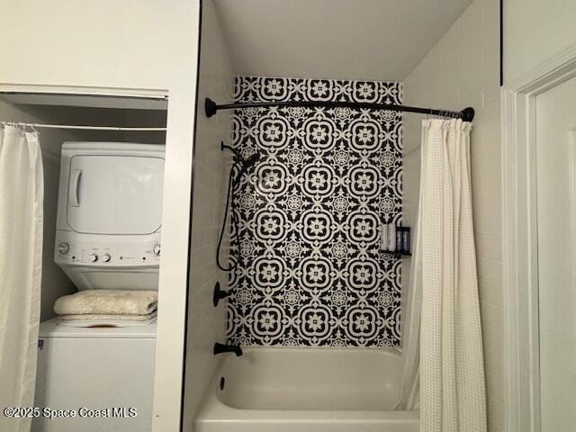 bathroom featuring stacked washer / drying machine and shower / bathtub combination with curtain