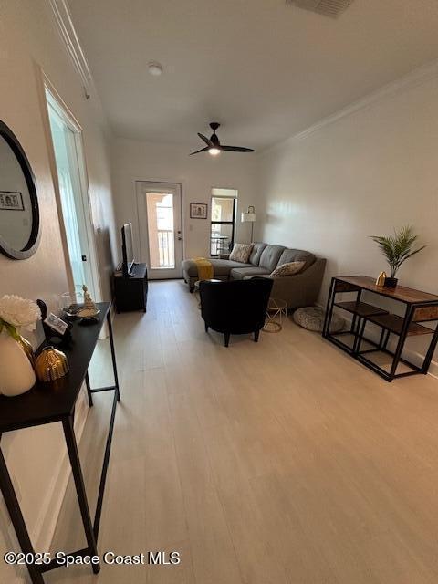 living room featuring light wood-type flooring, ceiling fan, and crown molding