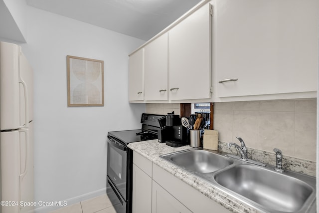 kitchen with white fridge, black electric range oven, white cabinetry, and decorative backsplash