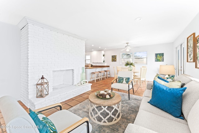 tiled living room with a brick fireplace and ceiling fan