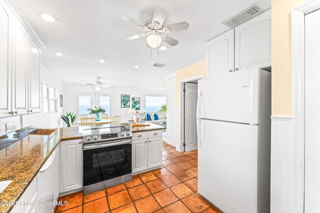 kitchen featuring white cabinetry, light tile patterned floors, white appliances, and dark stone countertops