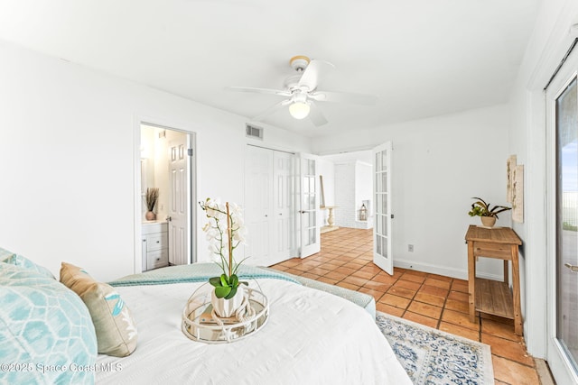 tiled bedroom with a closet, connected bathroom, ceiling fan, and french doors