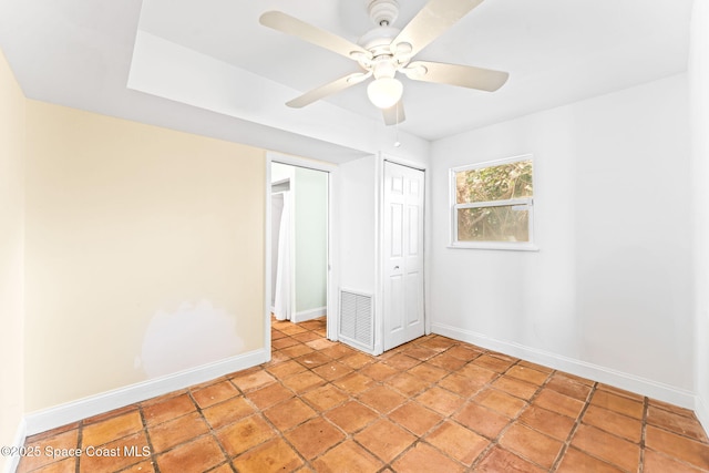 unfurnished bedroom with ceiling fan and a closet