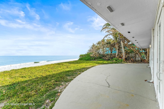 view of patio / terrace with a beach view and a water view