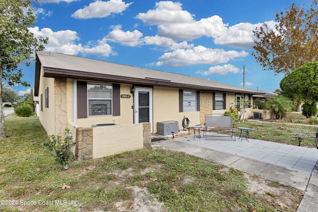 view of front of home with cooling unit, a patio area, and a front lawn