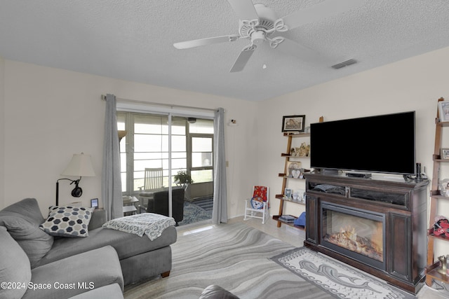 living room featuring a textured ceiling and ceiling fan