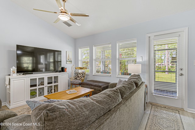 living room featuring ceiling fan, plenty of natural light, and lofted ceiling