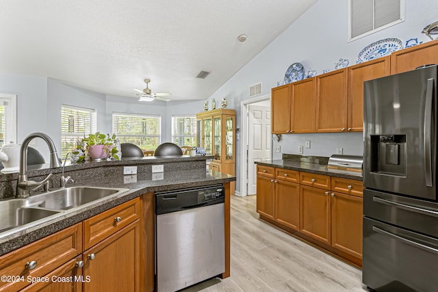 kitchen featuring sink, vaulted ceiling, ceiling fan, appliances with stainless steel finishes, and light hardwood / wood-style floors