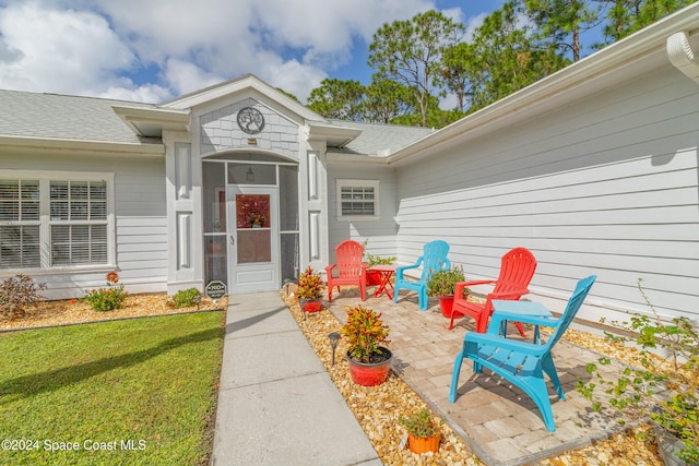 entrance to property with a yard and a patio