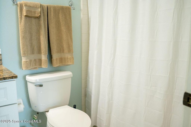 bathroom with toilet and curtained shower