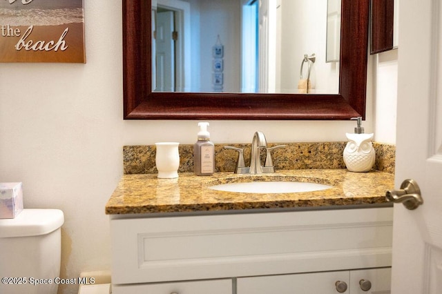 bathroom featuring toilet and vanity