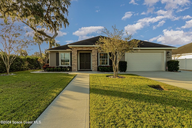 ranch-style home featuring a front lawn and a garage