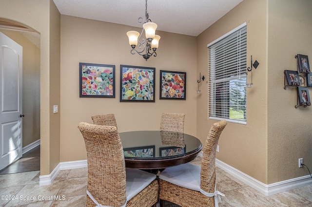 tiled dining room featuring a chandelier