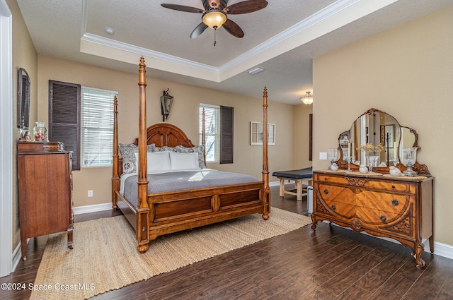 bedroom with crown molding, ceiling fan, wood-type flooring, and a raised ceiling