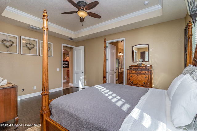 bedroom with dark hardwood / wood-style flooring, ornamental molding, ceiling fan, and a raised ceiling