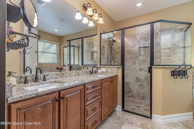 bathroom with vanity, a textured ceiling, and an enclosed shower