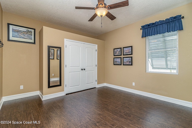 unfurnished bedroom with dark hardwood / wood-style flooring, a textured ceiling, a closet, and ceiling fan