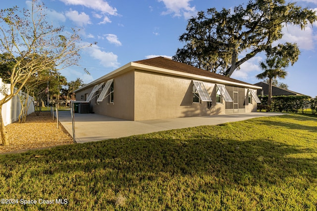 back of house with a patio area, central air condition unit, and a lawn