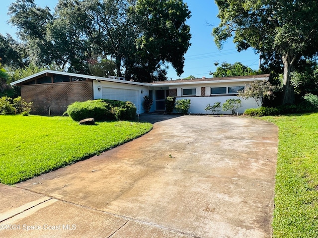 ranch-style home with a garage and a front lawn