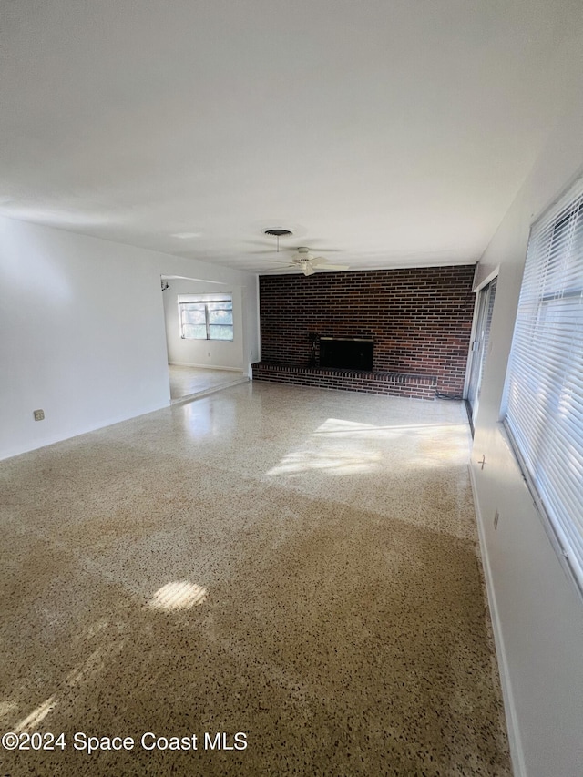 unfurnished living room with a brick fireplace