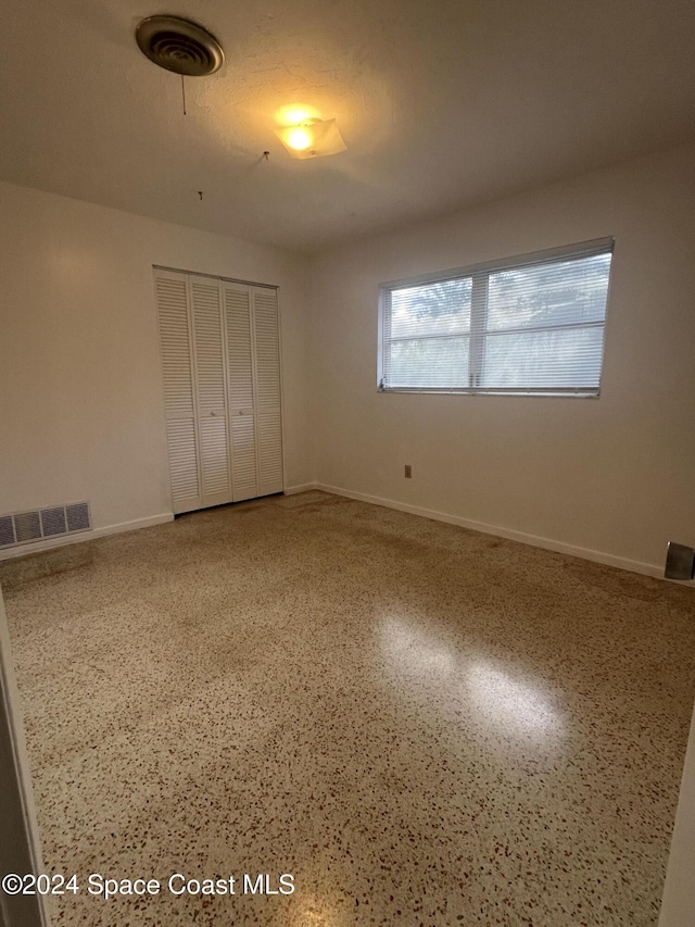 unfurnished bedroom featuring a textured ceiling and a closet