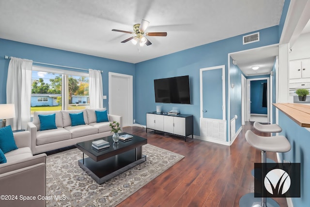 living room featuring ceiling fan and dark hardwood / wood-style floors