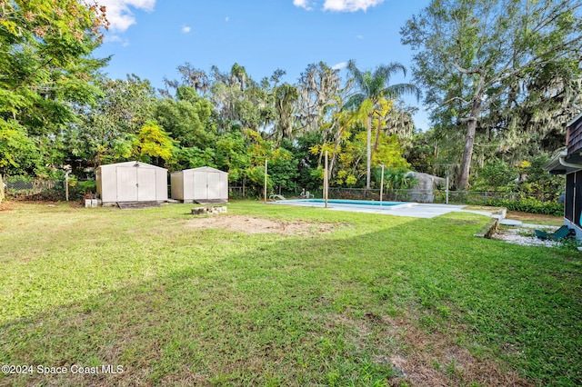 view of yard with a fenced in pool and a storage shed