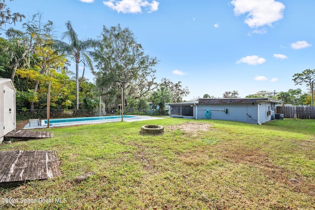 view of yard featuring a fire pit and a fenced in pool