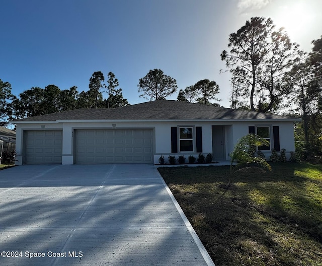 view of front of home featuring a front yard and a garage