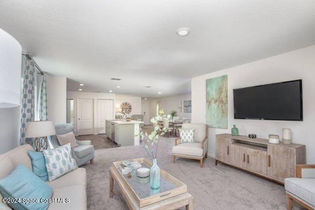 living area with light carpet and recessed lighting