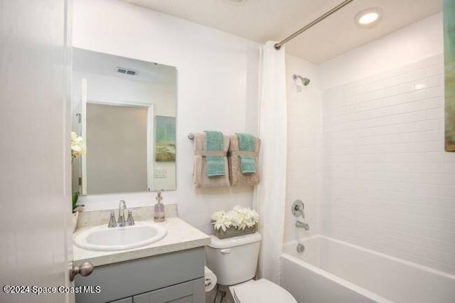 full bathroom featuring visible vents, shower / bath combo, vanity, and toilet