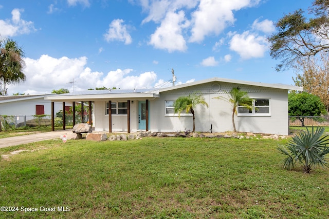 ranch-style home featuring a front lawn and a carport