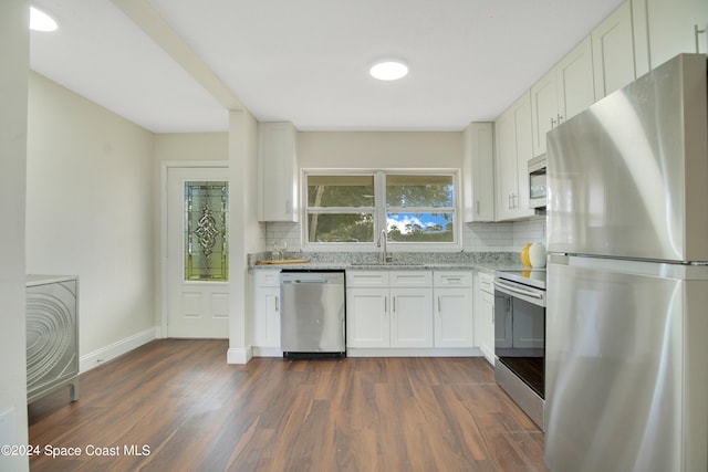 kitchen featuring appliances with stainless steel finishes, white cabinets, backsplash, and dark hardwood / wood-style flooring