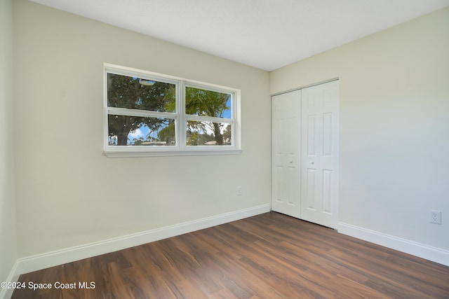 1610 Glen Haven Dr, Merritt Island, FL 32952 - unfurnished bedroom featuring baseboards, dark wood-style floors, and a closet