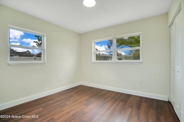 unfurnished bedroom with a closet and dark wood-type flooring