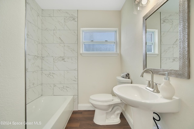 full bathroom featuring tiled shower / bath, sink, hardwood / wood-style flooring, and toilet